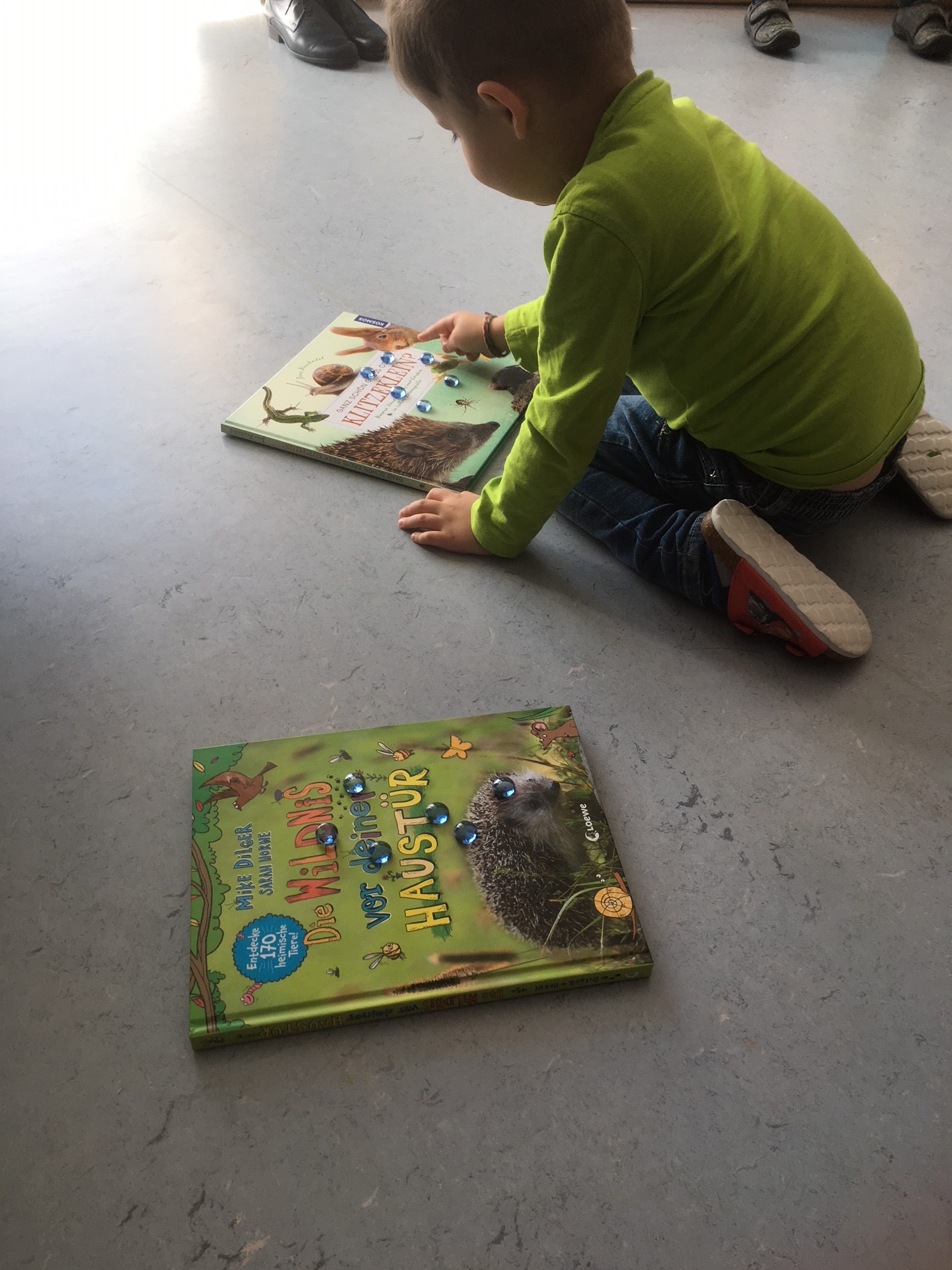 A small child places stones on a book